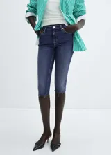 Jeans capri skinny de tiro medio, color azul denim, con cinco bolsillos, cierre de cremallera y botón, trabillas y bajo deshilachado.