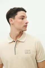 Polo color beige con textura, corte regular, logo estampado en el pecho y mangas cortas con ribete blanco.