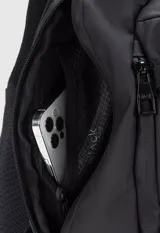 Bolso tipo bandolera color negro, con correa ajustable y cierres impermeables. Tiene un compartimento principal con cierre, dos compartimentos internos y un bolsillo interno con cierre para el celular.
