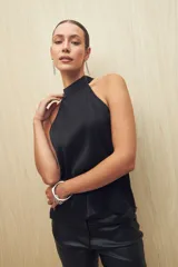 Top negro con cuello halter, sin mangas, de textura plisada y acabado satinado.