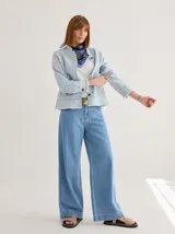 Campera de jean celeste de corte recto con cuello mao, bolsillos frontales y ruedo desflecado.