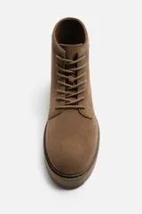 Bota de hombre color beige de cuero serraje con cordones, puntera redonda y suela track.