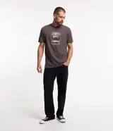 Remera gris de algodón con cuello redondo y mangas cortas. Presenta un estampado frontal de un reproductor de casete con la leyenda "To Travel".