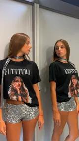 Remera negra de corte oversize con estampado frontal que incluye la palabra "FUTTTURA" en blanco y una imagen de una mujer de cabello largo y castaño.