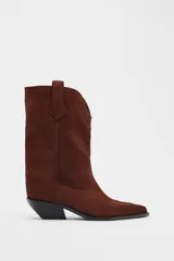 Botín de mujer estilo cowboy color marrón de serraje con puntera fina y tiradores laterales. Tacón de 5 cm.
