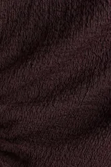 Top marrón sin mangas, de punto texturizado, con escote bote y cordones ajustables en un lateral y en un hombro.