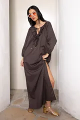 Vestido largo color marrón con tajos laterales, escote con volados y lazos con punteras metálicas.