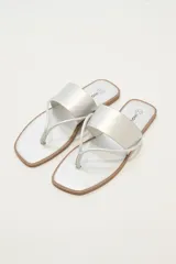 Sandalias plateadas con tira ancha sobre el empeine y tira fina entre los dedos.