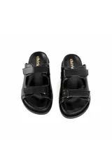Sandalias planas negras de cuero con textura y múltiples correas ajustables con velcro.