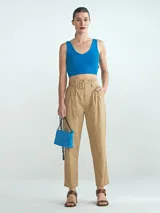 Pantalón de vestir color beige, de corte recto, con pinzas delanteras, bolsillos laterales y cinturón con hebilla forrada.