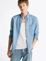 Camisa de denim celeste de Tommy Hilfiger de corte regular, con cuello abotonado, manga larga con puños abotonados, bolsillo de parche en el pecho y logo bordado en el bolsillo.