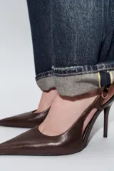 Zapato de tacón alto fino tipo slingback en piel color bordó. Presenta un diseño con acabado en punta, escote redondo y tira ajustable con hebilla metálica en el lateral.