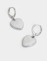 Aros dorados tipo argolla con dije colgante en forma de corazón blanco con diseño marmolado.