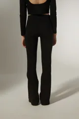 Calza negra de viscosa, corte oxford y tiro alto, con detalle de tachas plateadas en los laterales.