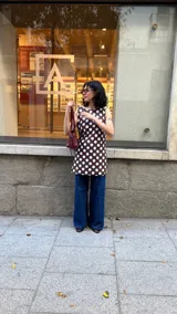 Vestido marrón con lunares blancos, de corte recto y sin mangas.