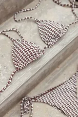 Conjunto de bikini azul con corpiño de triángulos movibles con almohadillas desmontables, que se ata al cuello y a la espalda. La bombacha es vedetina con tiritas a los costados para atar a medida de la cadera.