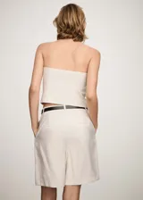 Top blanco strapless con cierre frontal y diseño entallado.