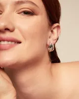 Par de aros plateados con cristal facetado negro y pequeños cristales blancos y rosados.