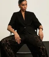 Blazer negro de viscosa con mangas cortas, solapas en el cuello y botón metalizado.