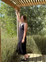 Vestido midi negro de corte recto con volados blancos en el cuello y sisas.