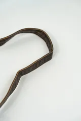 Cartera bandolera de cuero marrón oscuro con solapa y correa fina ajustable.