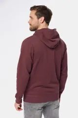 Canguro con cierre y capucha color bordó, confeccionado en felpa de algodón y poliéster.