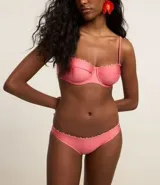 Bikini bombacha confeccionada en microfibra brillante color rosado, con detalle de pequeños adornos de madera en la cintura.