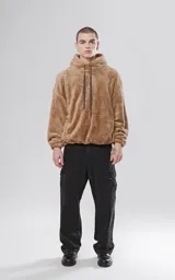Hoodie beige de piel de corderito sintético, corte oversize con cierre central al estilo anorak, capucha con cordón ajustable y bolsillo canguro.