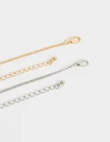 Set de dos collares con cadena de eslabones, uno dorado y otro plateado, con dije de conejo y zanahoria.
