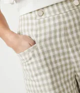 Short de tiro alto con estampado de cuadros en tonos beige y verde, con botones decorativos en la cintura.