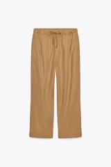 Pantalón jogger wide leg de tiro medio, color camel, confeccionado en hilatura con 23% de lino. Cuenta con cintura elástica ajustable con cordones, bolsillos laterales ocultos en costura y pierna ancha.
