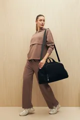 Canguro marrón con capucha, corte amplio y detalle de recorte frontal.