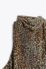 Vestido midi de viscosa con estampado animal print, cuello halter ajustable con lazos en la espalda y bajo asimétrico.
