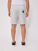 Bermuda deportiva gris confeccionada en 60% algodón y 40% poliéster, con cintura elástica ajustable con cordón.