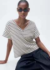 Camiseta de algodón a rayas horizontales blancas y negras, con cuello en V y corte recto.