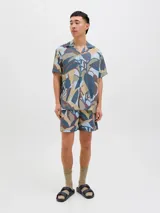 Short de baño con estampado abstracto en tonos celeste, marrón, beige y gris. Tiene cintura elástica con cordón ajustable, bolsillos laterales y un bolsillo trasero.