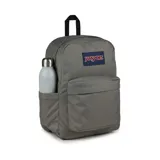 Mochila JanSport gris con logo en azul y rojo, con un compartimento principal amplio, un bolsillo frontal con cierre y tirantes acolchados.