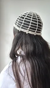 Gorro tipo vincha de crochet color crudo con diseño de rejilla.