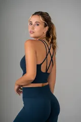 Top deportivo azul con espalda cruzada y textura acanalada.
