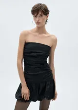 Vestido corto negro strapless con frunces en el cuerpo y falda con volados.