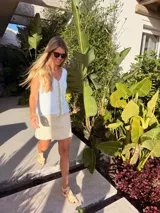 Musculosa tejida en látex metálico, con escote en V tanto en el frente como en la espalda, y detalle deshilachado en el frente.