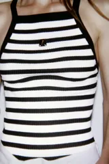 Top ajustado de rib a rayas horizontales blancas y negras, con escote recto y tirantes anchos. Tiene detalle de broche metálico en el frente y logo de Zara en la espalda.