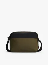 Bandolera Tommy Hilfiger color verde militar con detalles en negro y correa ajustable con la bandera de la marca. Incluye logo metálico en el frente y cierre de cremallera.