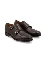 Zapato de vestir marrón oscuro para hombre, estilo monk strap con doble hebilla plateada y puntera redondeada.