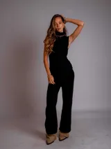 Conjunto de chaleco y pantalón tejido color beige. El chaleco es sin mangas y con cuello alto. El pantalón es de corte ancho.