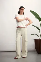 Pantalón cargo color verde oliva, de corte ancho, con bolsillos laterales con solapa y cintura con cordón ajustable.