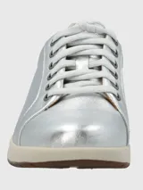 Zapatilla urbana de cuero color dorado, con cordones y suela blanca.