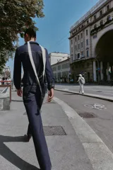 Jeans de mezclilla azul oscuro, tiro medio, corte recto y slim. Presenta costuras verticales marcadas en el frente de ambas piernas y viene con un cinturón de cuero marrón.