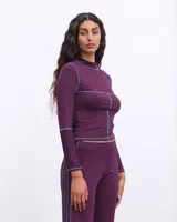 Remera color crudo de algodón con cuello alto y mangas largas.