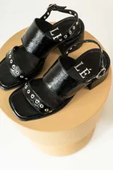 Sandalias de tacón de madera con tiras de gamuza marrón y detalles de tachas metálicas.